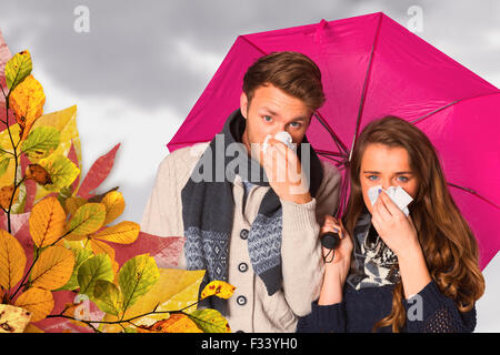 Image composite du couple blowing nose alors que holding umbrella Banque D'Images