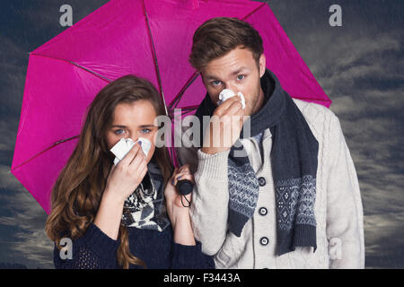 Image composite du couple blowing nose alors que holding umbrella Banque D'Images
