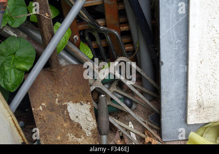 Scène de jardin avec un enchevêtrement de pelle, fourche et autres outils en bois et métal Banque D'Images