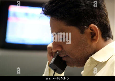 Les pourparlers sur le courtier pakistanais téléphone comme il suit les derniers prix des actions au cours de la séance de négociation à la Karachi Stock Exchange (SEC) à Karachi le Mardi, 29 Septembre, 2015. Banque D'Images