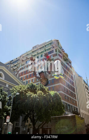 Athletic man doing back flip dans la ville Banque D'Images