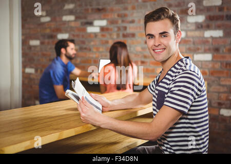 Jeune homme lisant un journal Banque D'Images