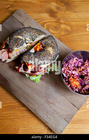 Bagel gastronomique et une salade de légumes sur une table en bois Banque D'Images