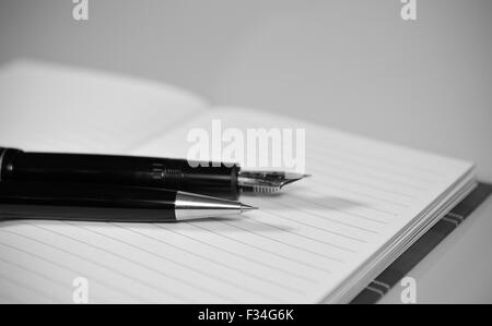 Portemine noir et blanc et stylo sur le portable Banque D'Images