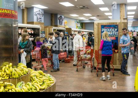 L'intérieurapt Trader Joe's Upper West Side en tant qu'homme en chemise fleurie détient panneau qui l'indique en fin de très longue ligne sinueuse check out Banque D'Images