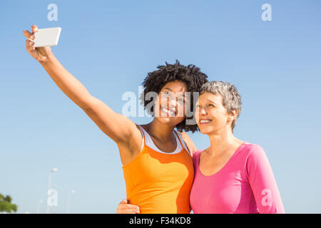 Deux femmes prenant des autoportraits smiling sporty Banque D'Images