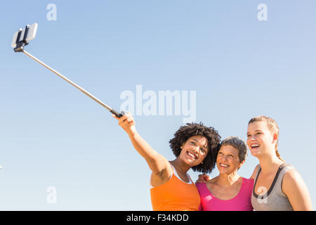 Smiling sporty women taking autoportraits avec selfiestick Banque D'Images