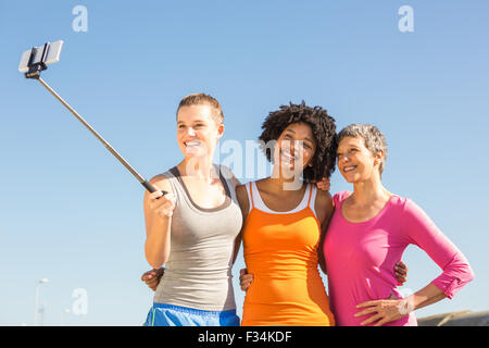 Smiling sporty women taking autoportraits avec selfiestick Banque D'Images