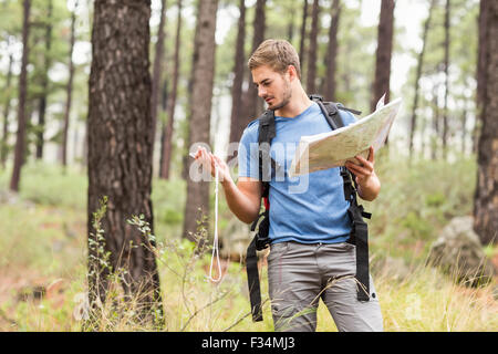 Les jeunes handsome hiker en utilisant la carte et boussole Banque D'Images