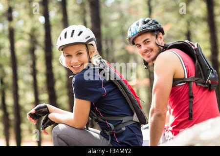Les jeunes motards heureux couple assis sur un rocher Banque D'Images