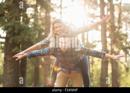Smiling handsome man giving piggy back pour sa petite amie Banque D'Images