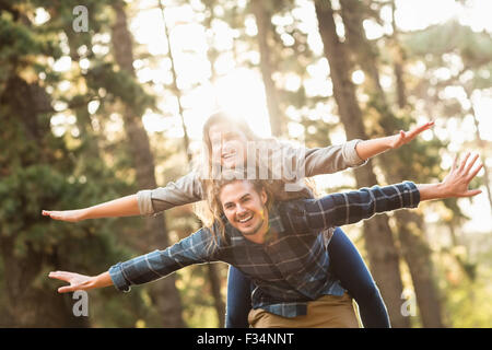 Smiling handsome man giving piggy back pour sa petite amie Banque D'Images