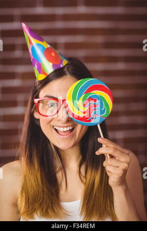 Jolie hipster avec chapeau de fête et une sucette Banque D'Images