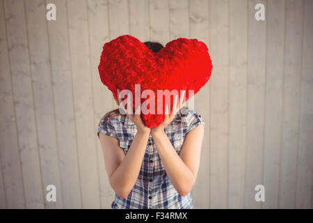 Jolie hipster holding heart pillow Banque D'Images