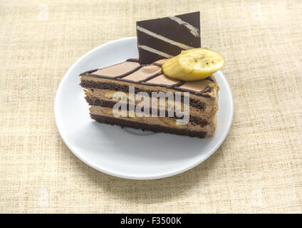 Café au Chocolat gâteau banane sur plaque blanche, fond de l'écorce Banque D'Images