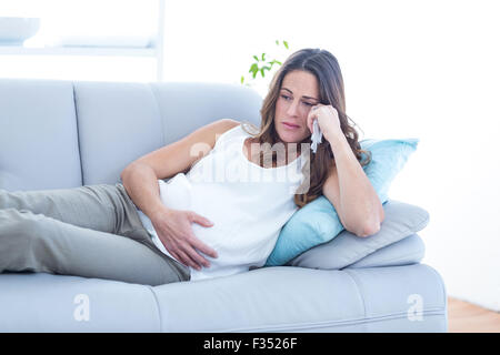 Triste pregnant woman lying on sofa Banque D'Images