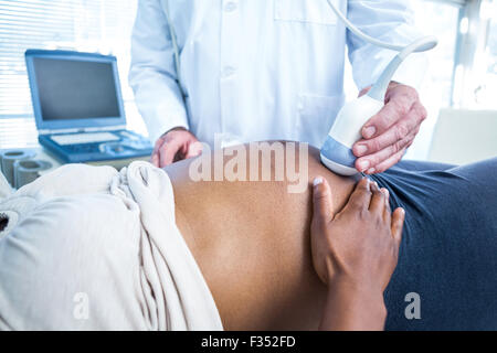 Section intermédiaire de médecin effectuant échographie de femme enceinte Banque D'Images