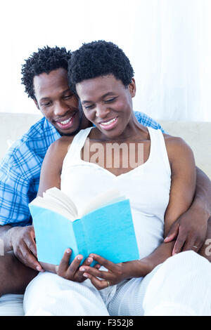 Femme enceinte et son mari reading book Banque D'Images