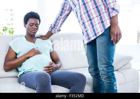 Triste pregnant woman sitting on couch Banque D'Images