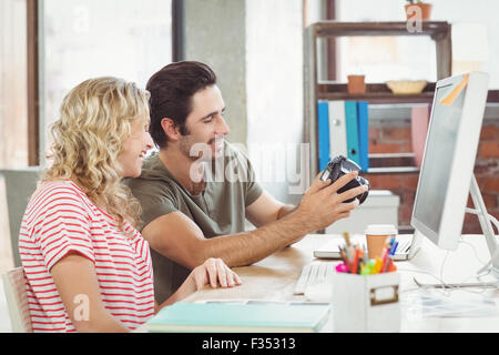 Man and Woman looking at digital camera in office Banque D'Images