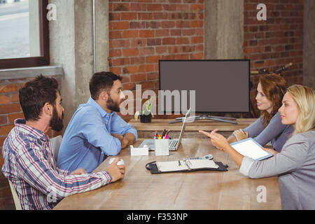 Businesswoman pointing vers collègues masculins dans office Banque D'Images