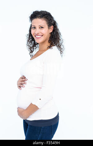 Portrait of happy pregnant woman holding abdomen Banque D'Images