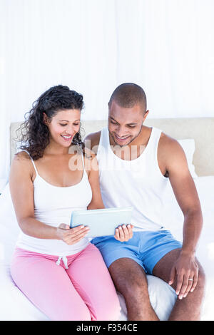 Heureux mari with pregnant wife holding digital tablet Banque D'Images