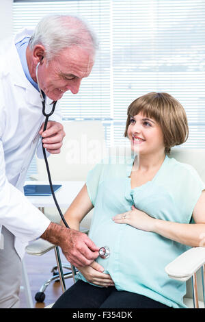 Doctor examining pregnant woman with stethoscope Banque D'Images