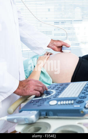 Médecin homme faire échographie de femme enceinte Banque D'Images