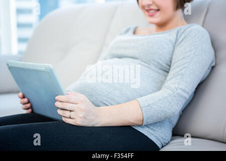 Portrait of pregnant woman using digital tablet Banque D'Images