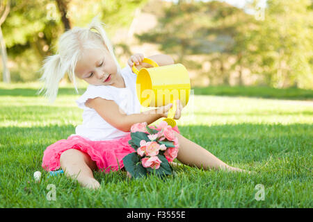 Cute Little Girl Playing jardinier ses outils et pot de fleurs. Banque D'Images