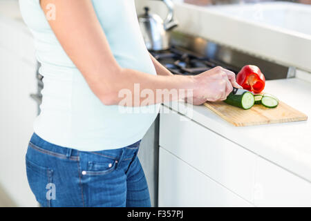 Midsection of woman cutting vegetables Banque D'Images
