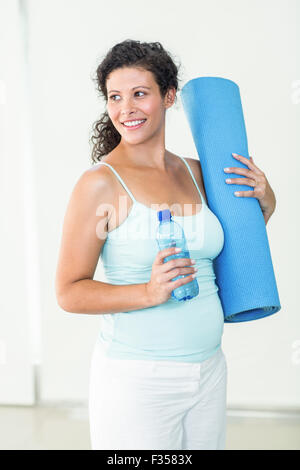 Pregnant woman holding tapis d'exercice et une bouteille d'eau Banque D'Images