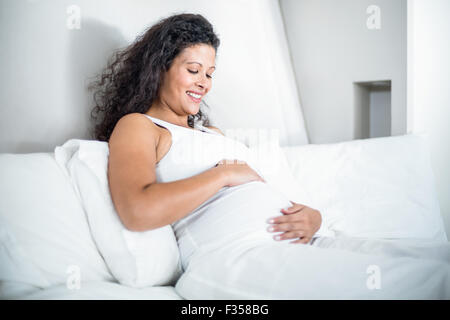 Jolie femme enceinte resting in bed Banque D'Images