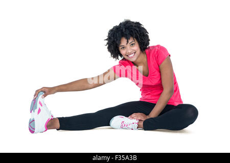 Portrait of young woman touching toes tout en exerçant Banque D'Images