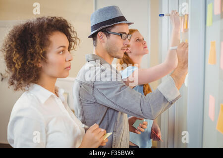 Les gens d'affaires notes sur la paroi de verre Banque D'Images