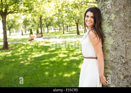Portrait of happy woman leaning on tree Banque D'Images