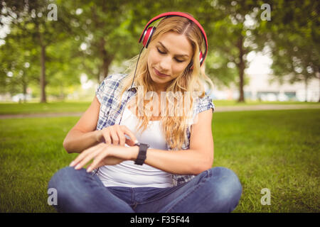 Femme d'écouter de la musique et de l'aide au stationnement smartwatch Banque D'Images