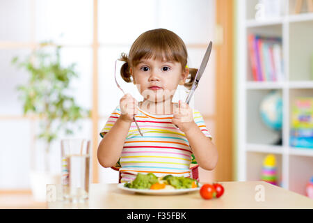 Petite fille avec fourchette et couteau prêt à manger Banque D'Images