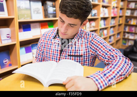 Young man reading book Banque D'Images