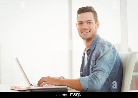 Portrait of smiling young man working on laptop Banque D'Images
