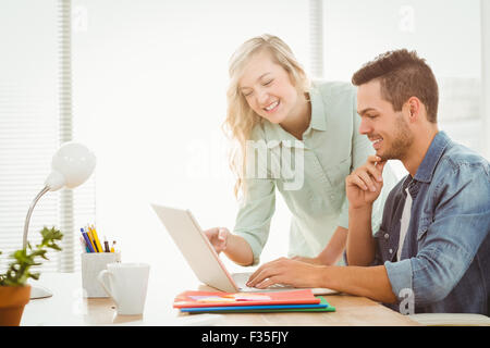 Happy young man and woman working on laptop Banque D'Images