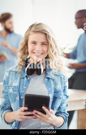 Portrait de femme heureuse avec des écouteurs en holding digital tablet Banque D'Images