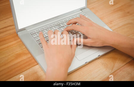 Man typing on laptop at desk in office Banque D'Images