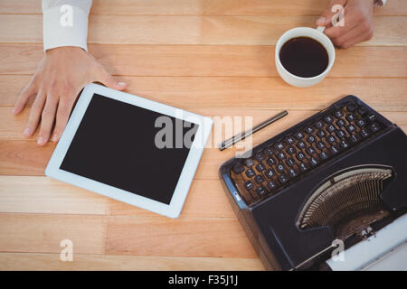 Businessman holding café noir avec machine à écrire et digital tablet Banque D'Images