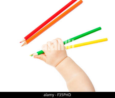 La main de l'enfant est titulaire d'crayons de couleur isolé sur fond blanc Banque D'Images