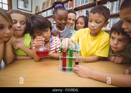 Les élèves et l'enseignant faire de la science dans la bibliothèque Banque D'Images