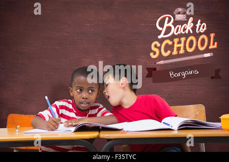Image composite de cute pupils écrit at desk in classroom Banque D'Images