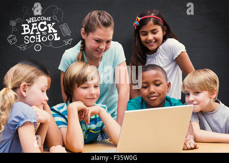 Image composite de cute pupils using tablet computer in library Banque D'Images