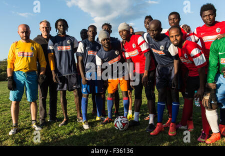 Egringen, Allemagne. Sep 29, 2015. Les réfugiés de l'hébergement partagé Efringen-Kirchen port SC Freiburg shirts posent pour une photo de l'équipe au cours d'une session de formation gratuite sur le terrain de sport à Egringen, Allemagne, 29 septembre 2015. L'équipe a fait don de 50 chemises, pantalons et chaussures de sport pour les réfugiés. Photo : Patrick Seeger/dpa/Alamy Live News Banque D'Images